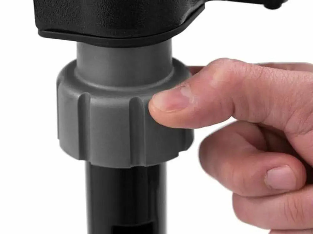 Close-up of a hand tightening the gray leg lock on the Broil King Porta-Chef Stove 200 portable propane stove.