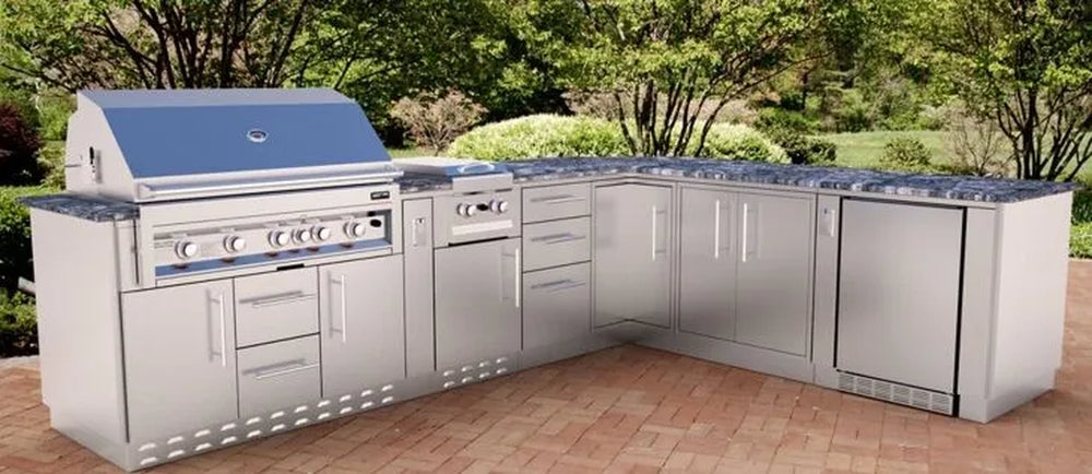 Outdoor kitchen layout featuring the Sunstone 30-inch triple drawer base cabinet integrated into a complete stainless steel grill island with a built-in gas grill and stone countertop.