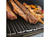 Close-up of ribs, chicken, and vegetables grilling on heavy cast iron cooking grates inside the Broil King Regal Charcoal Grill 400.
