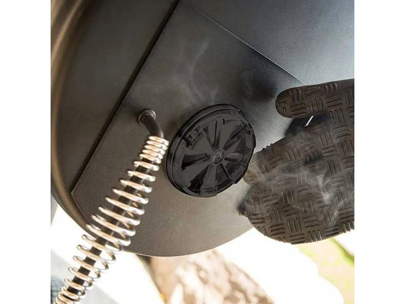 Close-up of the adjustable air vent and spring handle on the side firebox of the Broil King Regal Charcoal Offset 400 smoker grill.