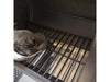 Close-up of the side firebox interior with charcoal being added to the grate inside the Broil King Regal Charcoal Offset 400 smoker grill.