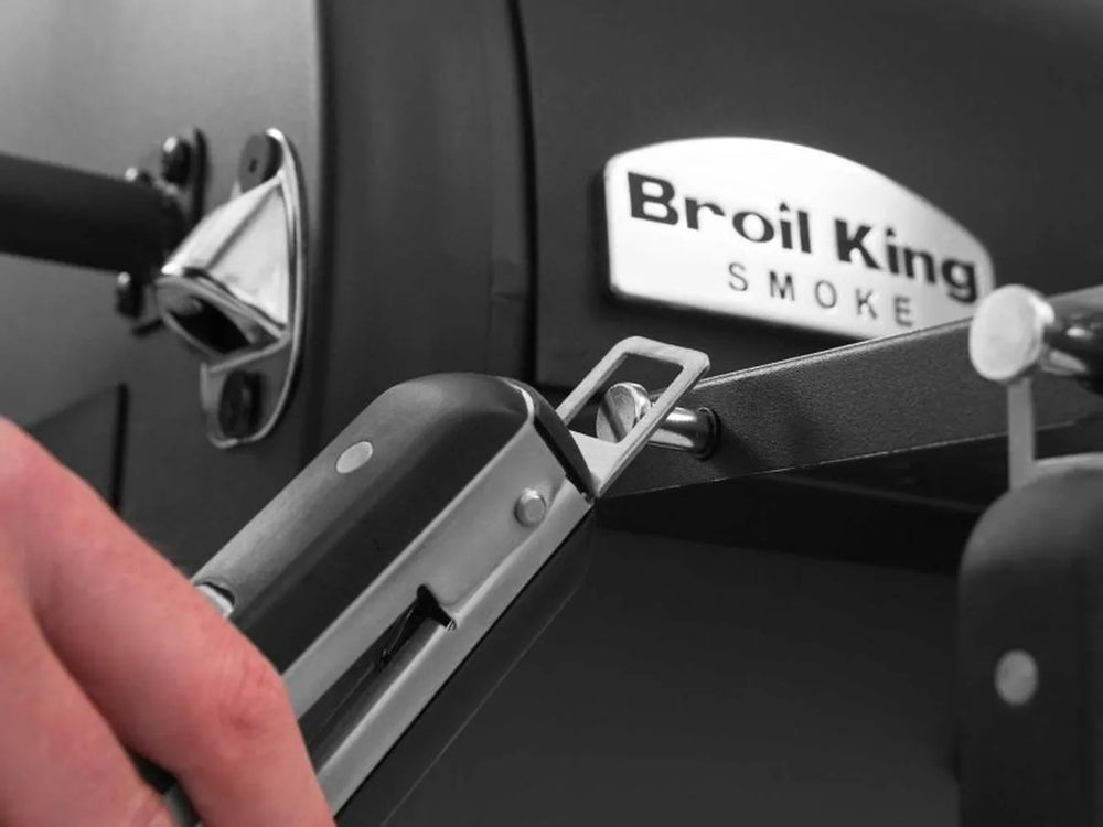 Built-in bottle opener mounted on the side of the Broil King Regal Charcoal Offset 500 smoker grill.
Close-up of a black transport wheel on the Broil King Regal Charcoal Offset 500 smoker grill cart.