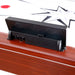 Back view of the electronic scoreboard on the air hockey table showing speaker holes and battery compartment. Mounted to the wood-trimmed frame of the table.