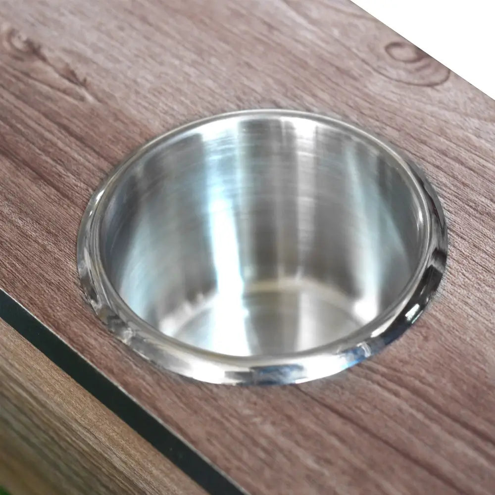 Metallic built-in cup holder inset into the foosball table’s wood-tone surface, designed to hold drinks during gameplay.
