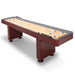 Hathaway shuffleboard table with rich cherry finish, carpeted gutters, and included blue and red pucks on a polished butcher block playfield.
