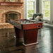 Espresso-finish foosball table with chrome accents and modern pedestal legs, staged in an elegant game room with brick fireplace and leather chair.