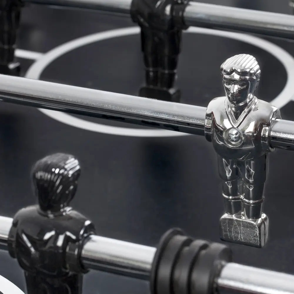 Close-up of ABS counter-balanced foosball player figures in black and chrome, mounted on durable chrome rods over a precision playfield.