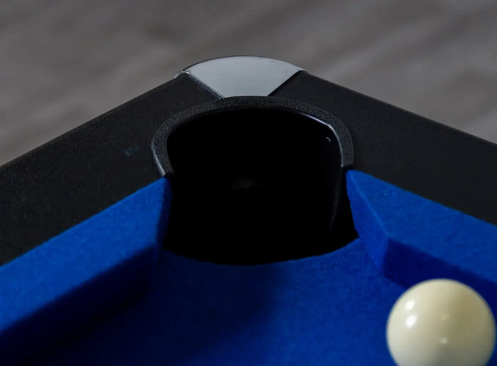 Corner pocket of Hathaway Hustler pool table featuring blue wool-blend felt, black top rails, and chrome-plated corner cap for added durability and modern style.
