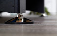 Close-up of adjustable chrome leg leveler on Hathaway Hustler pool table, resting on a hardwood floor for leveling and stability during gameplay.