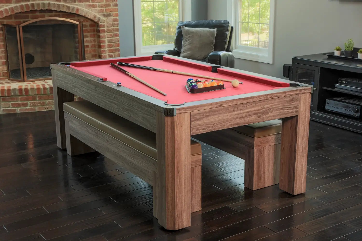 Lifestyle room scene of the Hathaway Newport 7-ft combo table styled as a rustic driftwood dining table with benches next to a brick fireplace.