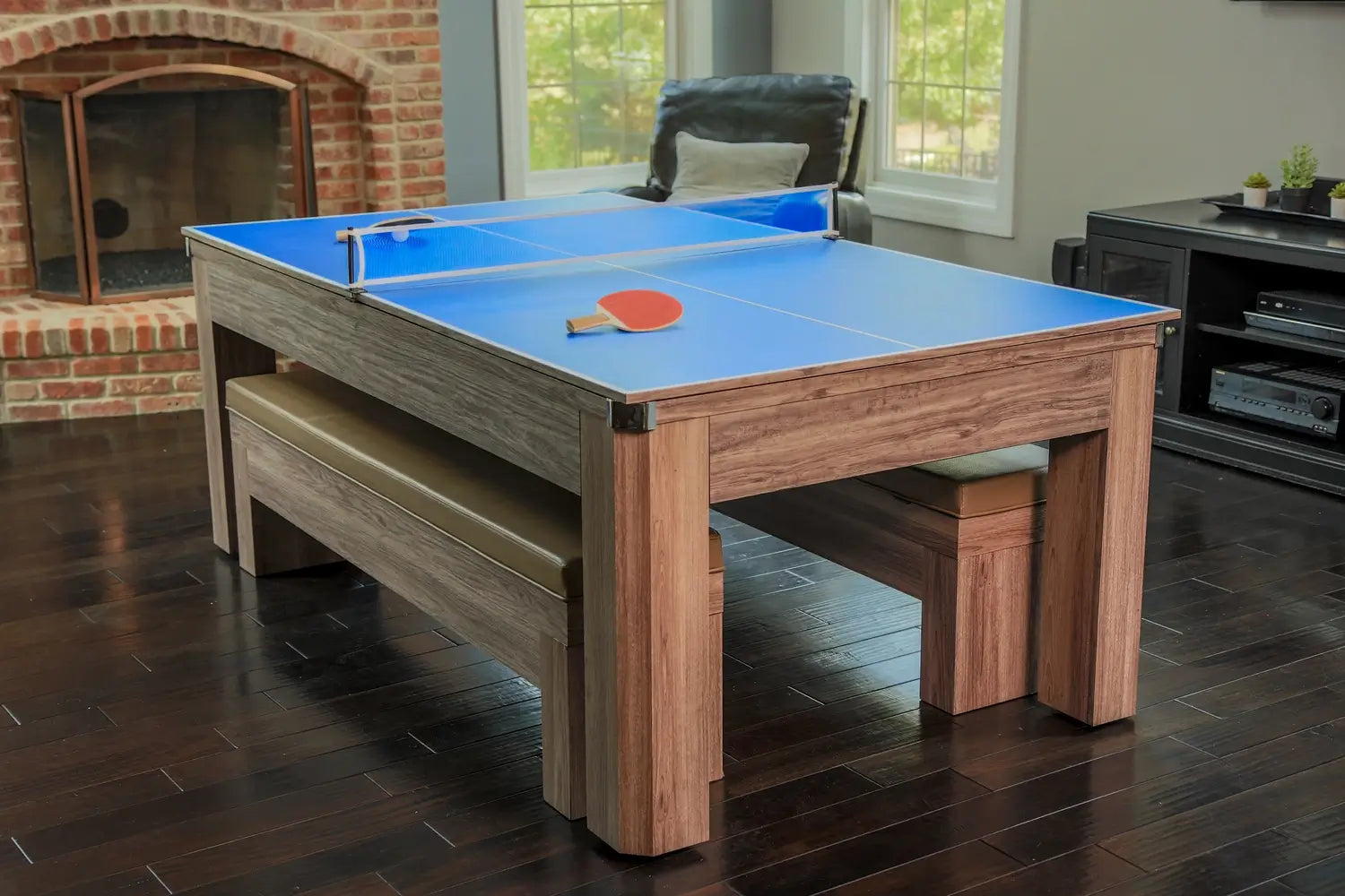 Lifestyle home setting of the Hathaway Newport multi-game table set up with its blue table tennis conversion top and paddles.