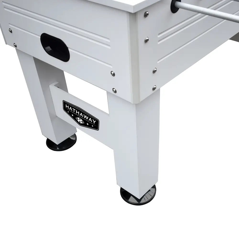 Angled view of white foosball table leg and side panel construction, highlighting reinforced corners, adjustable round leg levelers, and visible hardware.