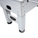 Angled view of white foosball table leg and side panel construction, highlighting reinforced corners, adjustable round leg levelers, and visible hardware.