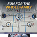 Top-down view of the Breakaway Hockey Table playfield featuring red and blue player figures, rink graphics, two goals, and center ice with 'Breakaway' branding.