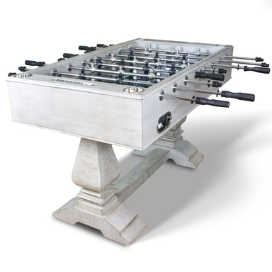 Full angled view of whitewashed farmhouse foosball table with sculpted dual pedestals, chrome rods, built-in drink holders, and classic arcade design.