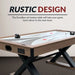 Rustic design of Excalibur air hockey table with wood grain finish and bold black X-base, ideal for enhancing game room aesthetics and modern decor.