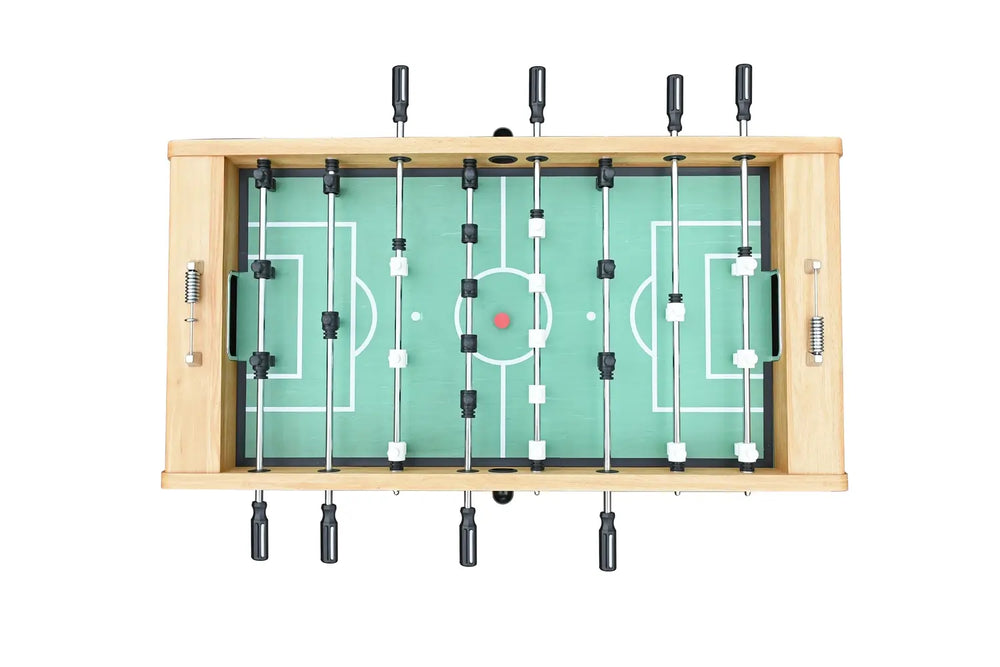 Overhead view of foosball table with light oak finish, green soccer field design playfield, black and white player rods, and red center ball.