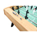 Detailed view of chrome-plated manual score counter mounted on a light oak foosball table with green field and player rods.
