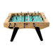 Backside of foosball table with curved apron design, 3-player goalie setup, black handles, and central red ball on green playfield.