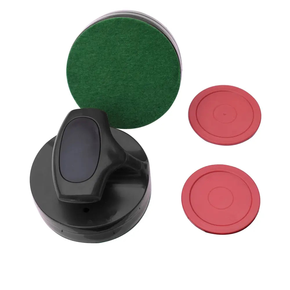 Close-up of ergonomic black air hockey striker with green felt-lined base and two red pucks placed on a white background. Designed for smooth glide and accurate control during gameplay.