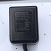 Close-up of label on Class 2 AC/DC power adapter for air hockey tables. Model JY35-060-030-UD with input 120V AC 60Hz 55mA and output 6V DC 300mA. UL-listed adapter, marked “For indoor use only,” shown on air hockey table surface.