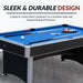 Hathaway pool table with blue felt and matte black melamine coating, displayed in a modern room setting with included accessories like cue sticks, chalk, and racked billiard balls.