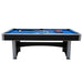 Side profile of a mid-size Hathaway pool table featuring a blue polyester-wool felt surface, chrome-plated corners, and included accessories like cue sticks, chalk, and billiard balls.