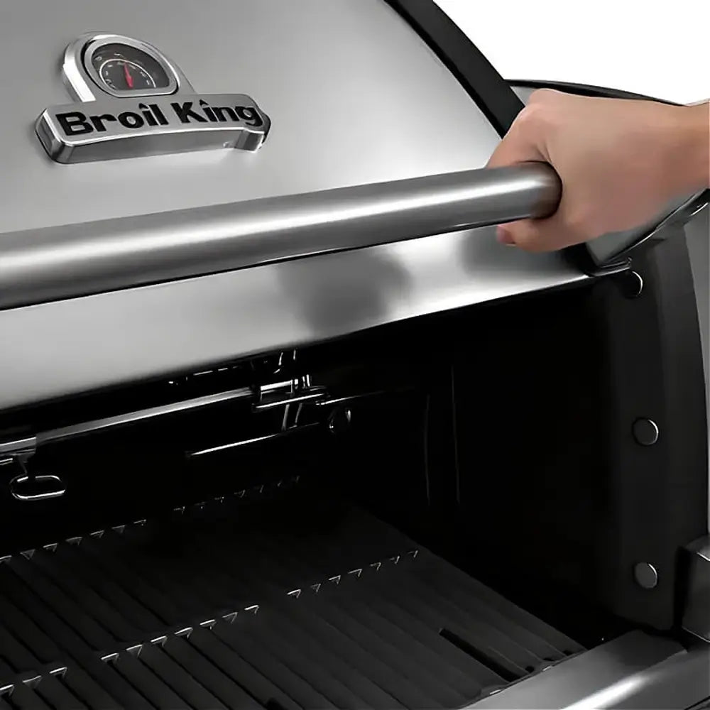 Close-up of the Broil King Imperial S-690i 6-burner gas grill lid being opened, showing the stainless steel handle and integrated hood thermometer.