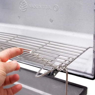 Adjustable upper warming rack inside the Broilmaster grill, demonstrating easy access and sturdy hinge design
