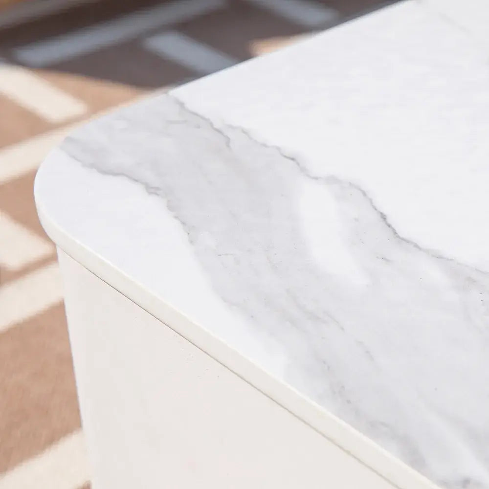 Close-up detail of the realistic white marble veining on the Elementi Annecy porcelain fire table surface.