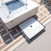 Top-down view of the Elementi Annecy fire table showing the functional sliding drawer for under-table lid storage.
