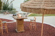 Lit Elementi OFG224 Rova Fire Bar Table 40k BTU on a coastal balcony during sunset with atmospheric lighting.