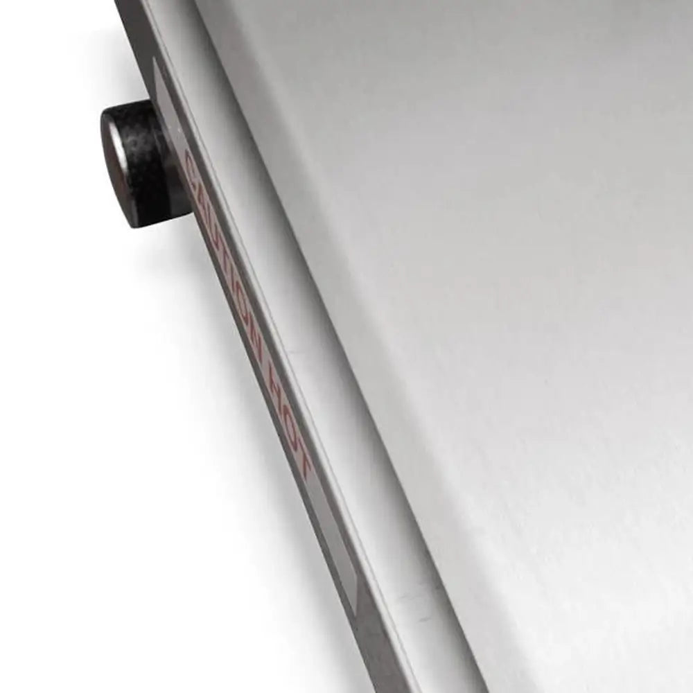 Close-up of Le Griddle stainless steel edge with hot surface caution label.