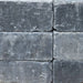 Close-up texture of the Granite color finish for the Travertine TessaRai Gas Fire Pit, featuring charcoal and deep grey stone blocks.