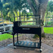 Tagwood BBQ03SI Santa Maria charcoal grill with side table near waterfront backyard