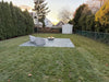 Modern backyard patio installation of a 40-inch TessaRai fire water bowl feature at sunset.