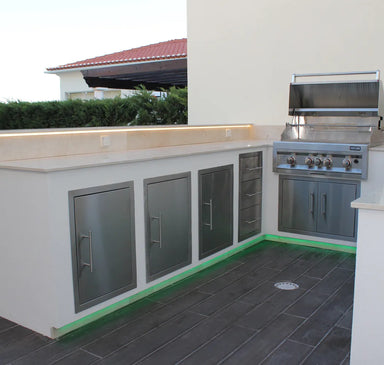 Sunstone 16-inch reversible access door installed in outdoor kitchen island with stainless cabinets and built-in grill.