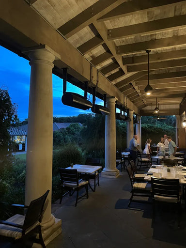 Wind-protected restaurant patio using SunStar SGL1560 48-inch glass infrared heaters for year-round dining.