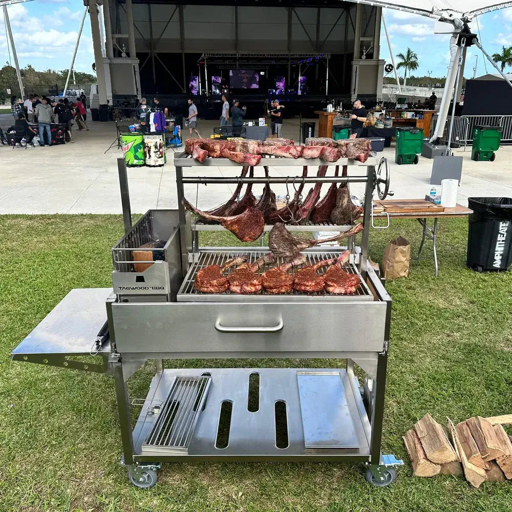 Tagwood BBQ23SS XL Santa Maria grill cooking tomahawk steaks and hanging meats at BBQ festival