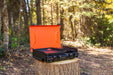 Outdoor setup showing black camping griddle with side burner on picnic table