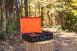 Outdoor setup showing black camping griddle with side burner on picnic table