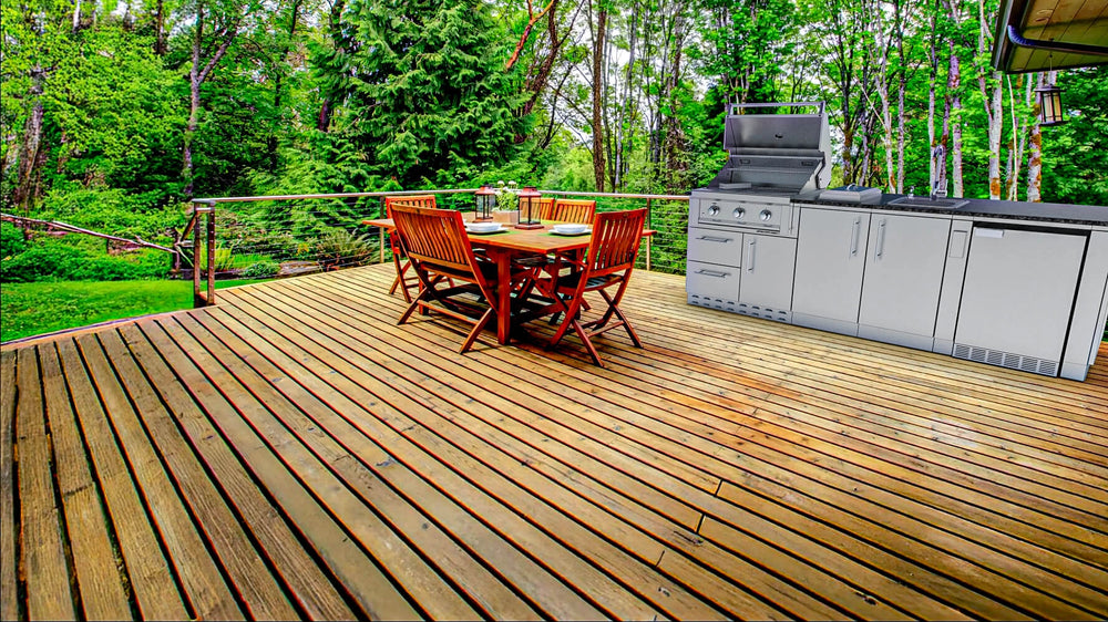 Sunstone SCPBAYOU8.6 Bayou Outdoor Kitchen Island 8'6" on outdoor wood deck patio with dining set—grill, fridge and sink setup.