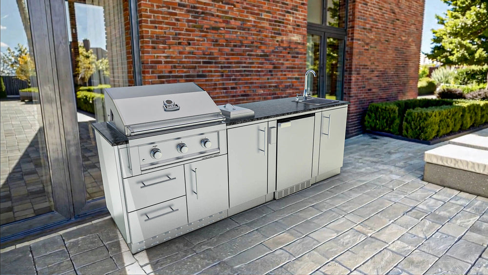 Sunstone SCPBAYOU8.6 Bayou Outdoor Kitchen Island 8'6" outdoor kitchen run installed on stone patio with scenic garden.
