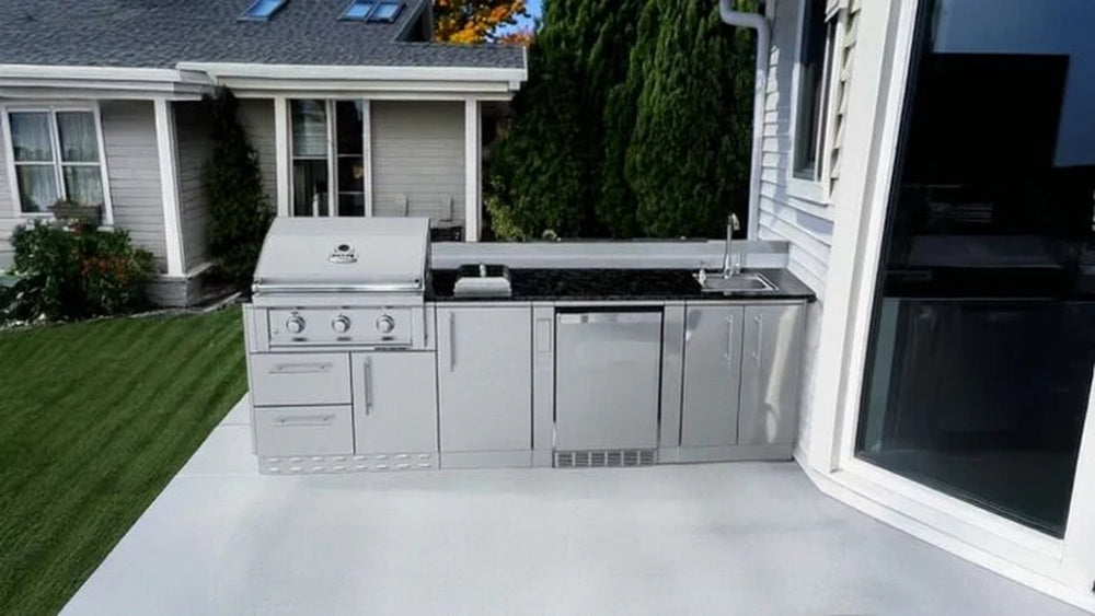 Sunstone SCPBRAZOS9 Brazos 9-foot outdoor kitchen island with a built-in gas grill and sink installed on a modern concrete patio.