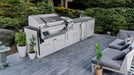 Sunstone SCPCYPRESS11.6 Cypress Outdoor Kitchen Island installed on modern patio with stainless grill, side burner, sink, fridge, and storage cabinets.