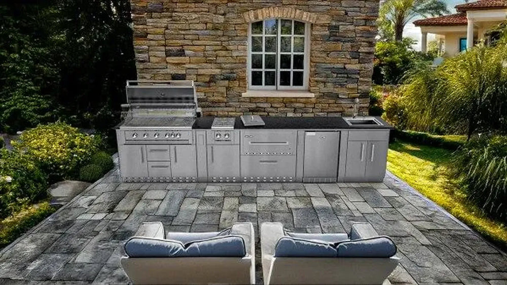 Sunstone SCPFRENCHQUARTER13.7 French Quarter Island lifestyle view on stone patio with built-in grill, warming drawers, fridge, and sink station.