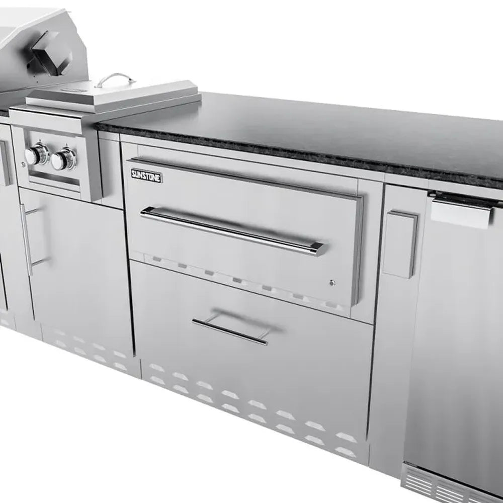 Sunstone SCPFRENCHQUARTER13.7 French Quarter Island close-up of stainless warming drawer cabinet next to side burner and under-counter refrigerator.