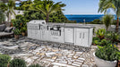 Luxury coastal installation of the Sunstone SCP-HILLCOUNTRY-13.6 outdoor kitchen on a stone mosaic patio with ocean views and palm trees.