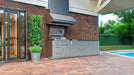 Sunstone SCPMAGNOLIA10 Magnolia ADA Kitchen Island 10 ft outdoor kitchen setup by brick house and pool with vent hood, stainless grill, side burner, and sink.