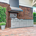 Sunstone SCPMAGNOLIA10 Magnolia ADA outdoor kitchen island installed on brick patio with vent hood, Ruby grill, side burner, sink, and storage cabinets.